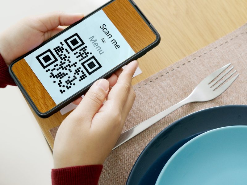 Hand's customer scan QR code for online menu service at table in restaurant